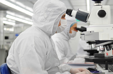 身着洁净服的制药生产线工人